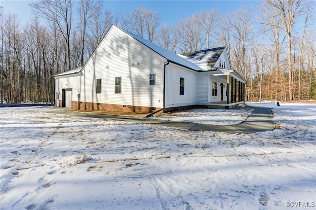 view of snow covered exterior with crawl space and covered porch