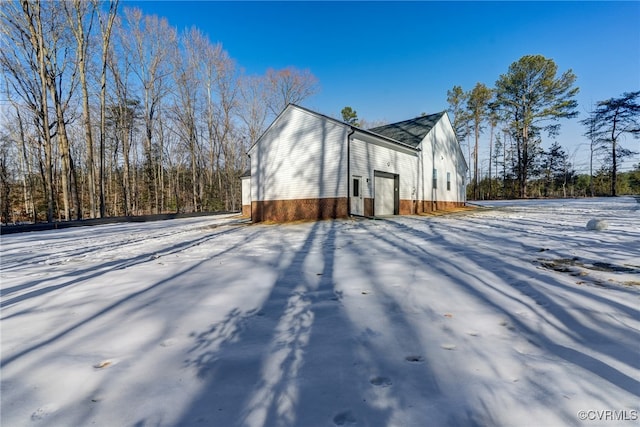 view of snow covered exterior featuring brick siding