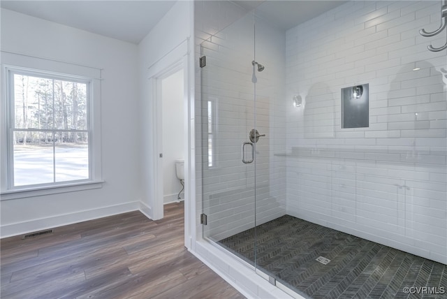 full bathroom with toilet, wood finished floors, visible vents, baseboards, and a stall shower