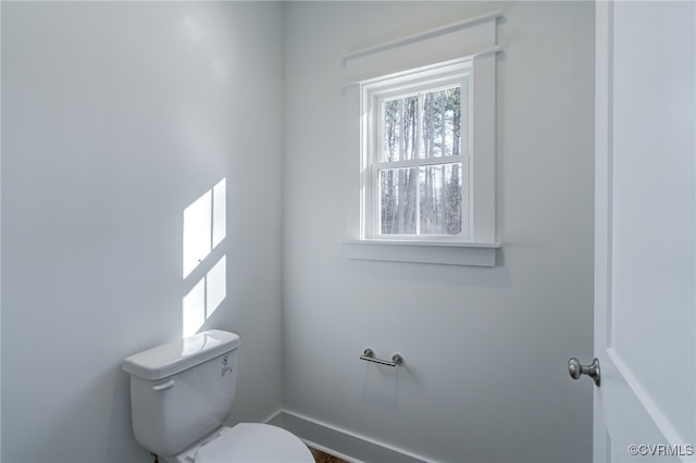 bathroom with toilet and baseboards