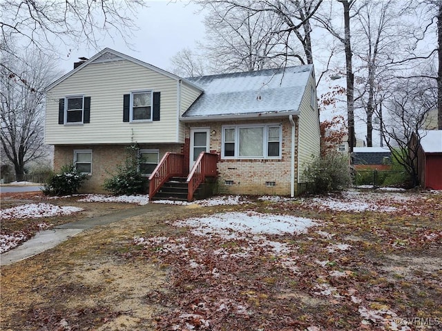 split level home with crawl space, a shingled roof, a chimney, and brick siding