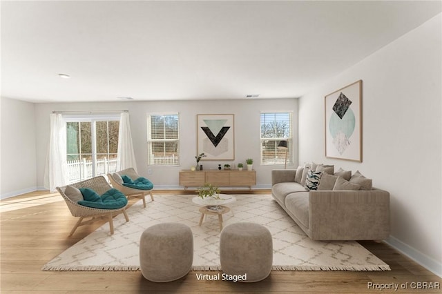 sitting room with visible vents, baseboards, and wood finished floors