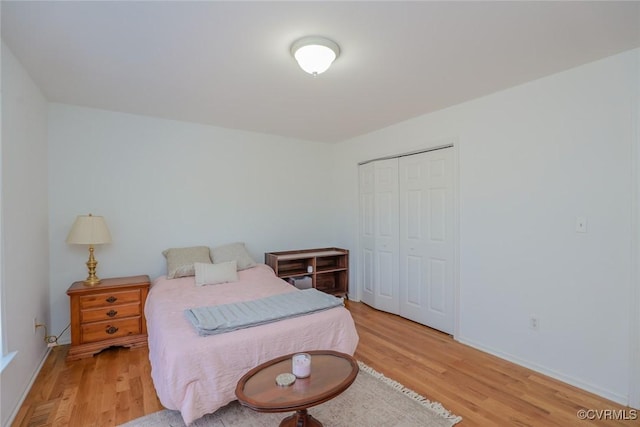 bedroom featuring a closet, light wood-type flooring, and baseboards