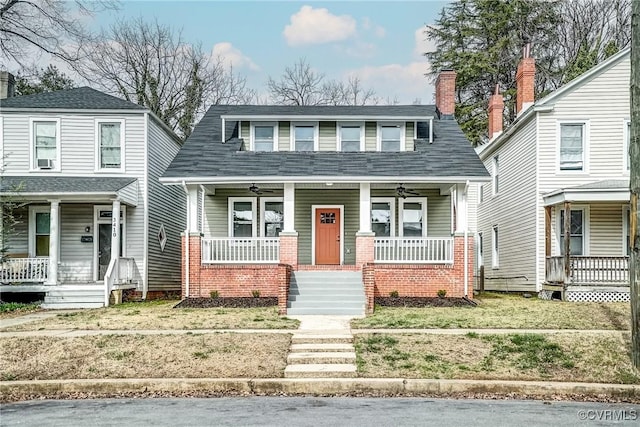 view of front of property featuring a porch, a ceiling fan, brick siding, and a chimney