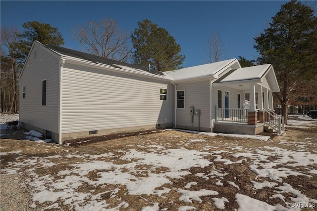 snow covered property with crawl space and covered porch