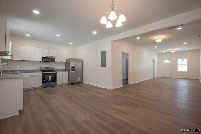 kitchen featuring stainless steel appliances, visible vents, open floor plan, white cabinetry, and electric panel