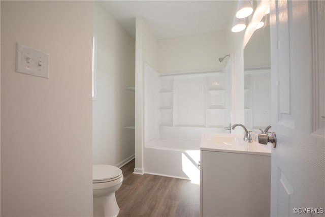 bathroom featuring toilet, washtub / shower combination, wood finished floors, and vanity