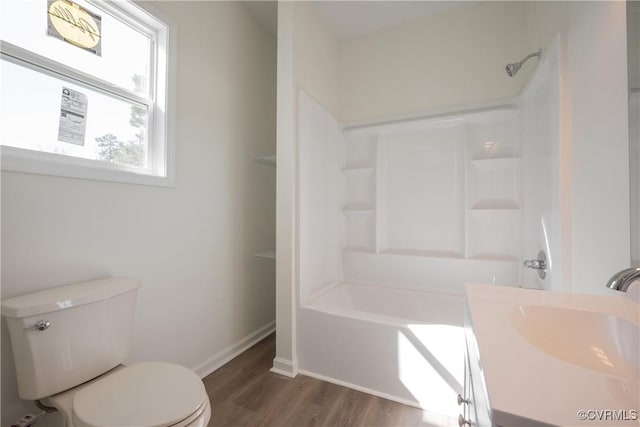 full bathroom with shower / washtub combination, a sink, toilet, and wood finished floors