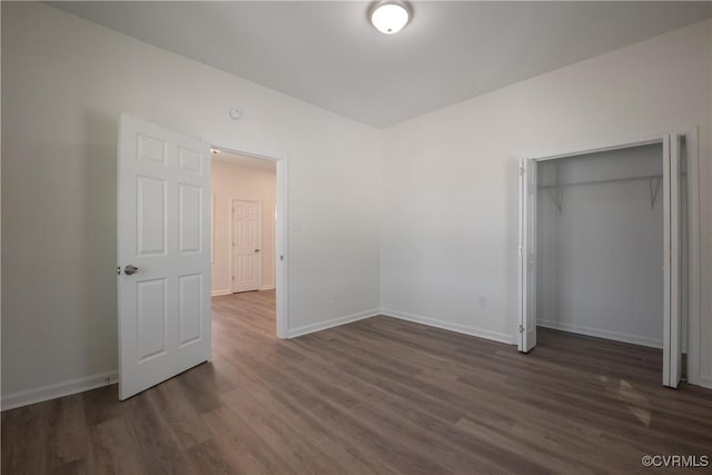 unfurnished bedroom featuring a closet, baseboards, and dark wood-type flooring