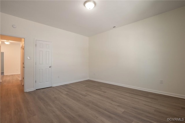 unfurnished room with baseboards and wood finished floors