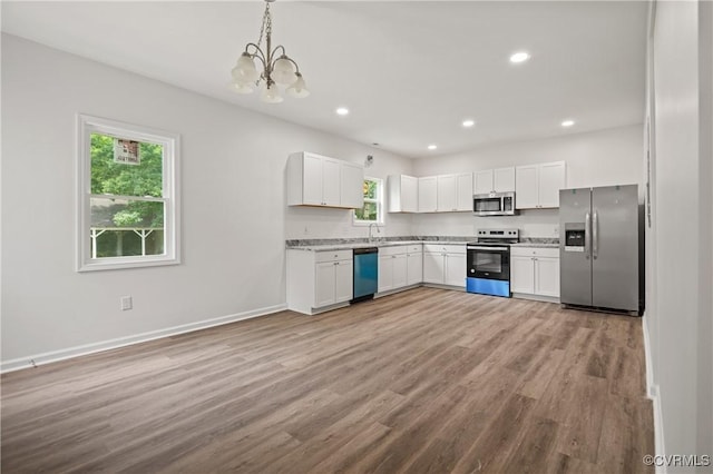 9214 River Rd, Chesterfield, VA 23803 - kitchen with appliances with stainless steel finishes, wood finished floors, a chandelier, white cabinetry, and recessed lighting