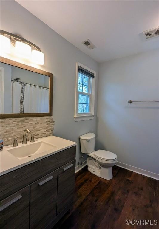 bathroom featuring visible vents, backsplash, toilet, and wood finished floors