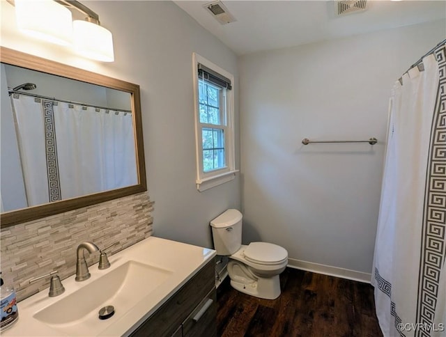 bathroom featuring decorative backsplash, toilet, wood finished floors, and visible vents