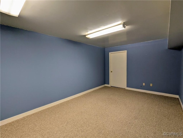 carpeted spare room with baseboards