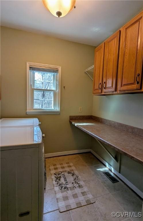 laundry room featuring cabinet space, visible vents, washer and dryer, and baseboards