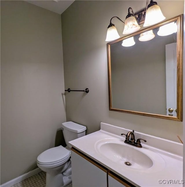 bathroom with vanity, toilet, baseboards, and tile patterned flooring