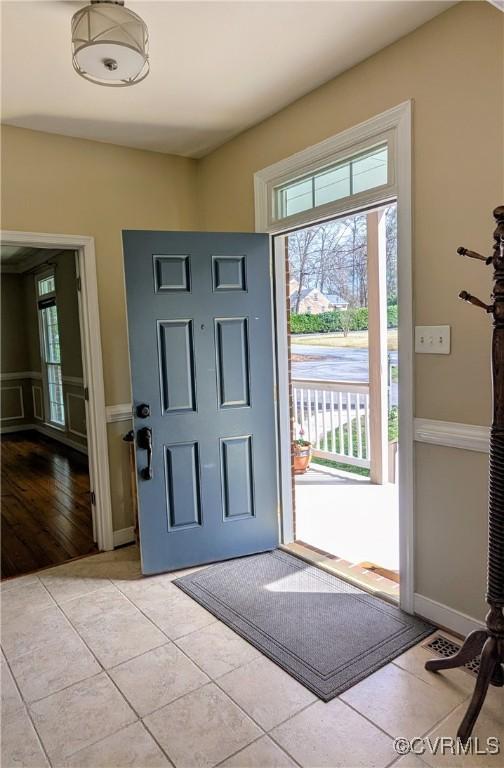 entryway with light tile patterned flooring and baseboards