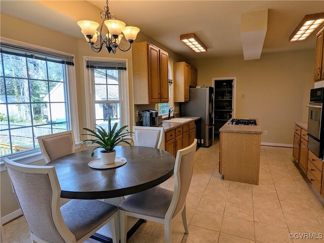 dining space with light tile patterned floors, a notable chandelier, and baseboards