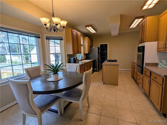 dining space with light tile patterned floors, baseboards, and a notable chandelier