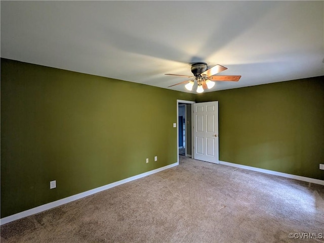 carpeted empty room featuring baseboards and ceiling fan