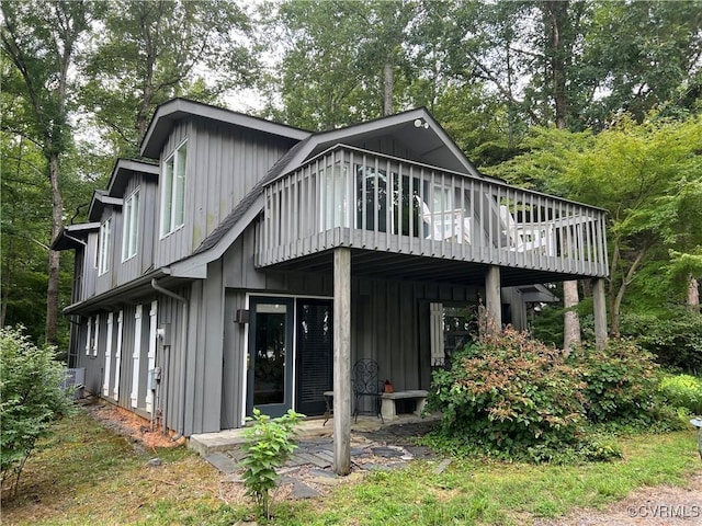 back of house featuring a deck and board and batten siding