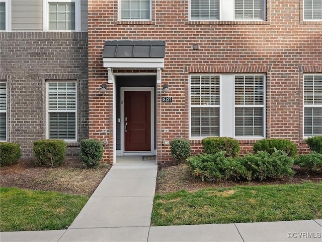 entrance to property featuring brick siding