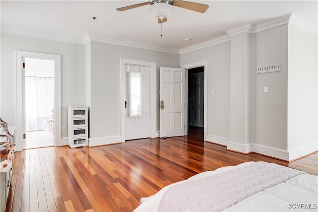 bedroom featuring baseboards, connected bathroom, ornamental molding, and wood finished floors