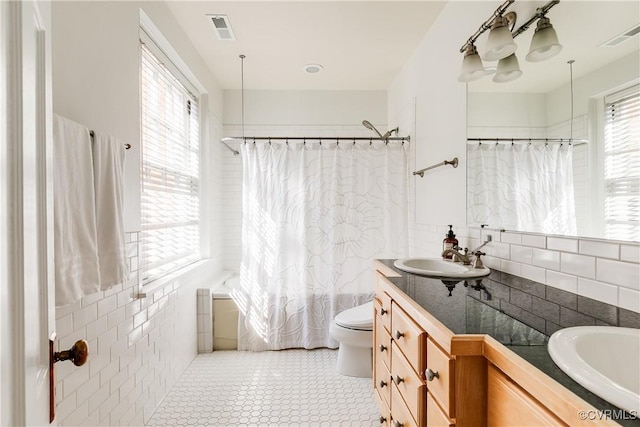 full bath featuring visible vents, plenty of natural light, vanity, and toilet