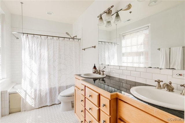 full bathroom with toilet, visible vents, vanity, decorative backsplash, and shower / bath combo with shower curtain