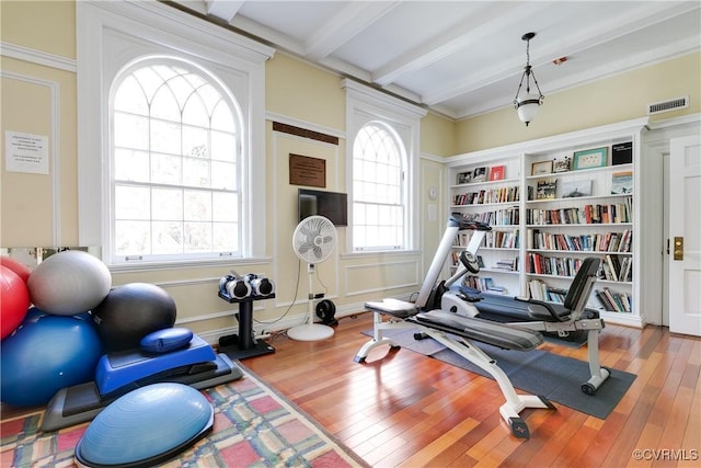 exercise area with visible vents and wood finished floors