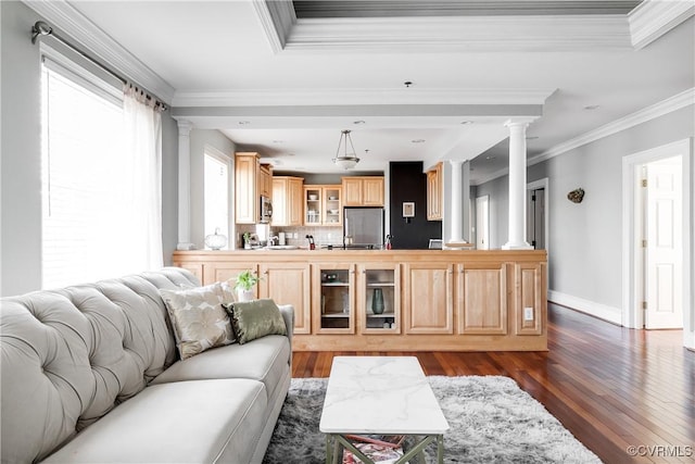 living area with ornate columns, dark wood finished floors, and crown molding