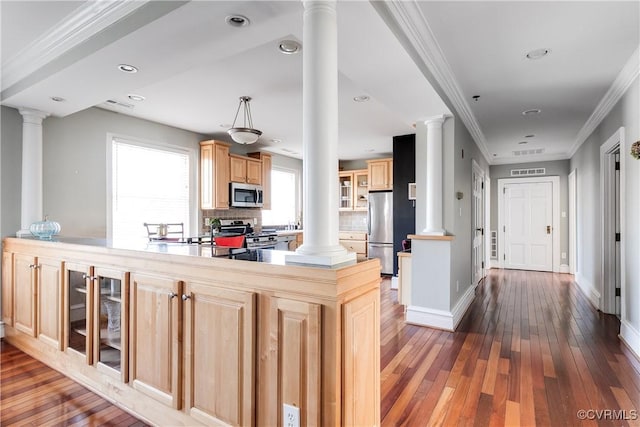 kitchen with stainless steel appliances, backsplash, glass insert cabinets, light brown cabinets, and ornate columns