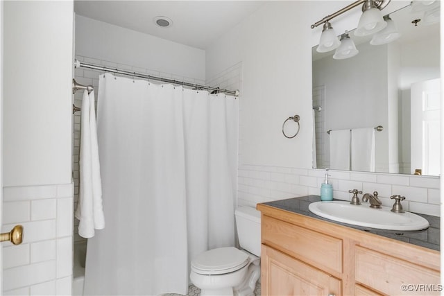 full bath featuring toilet, tile walls, and vanity