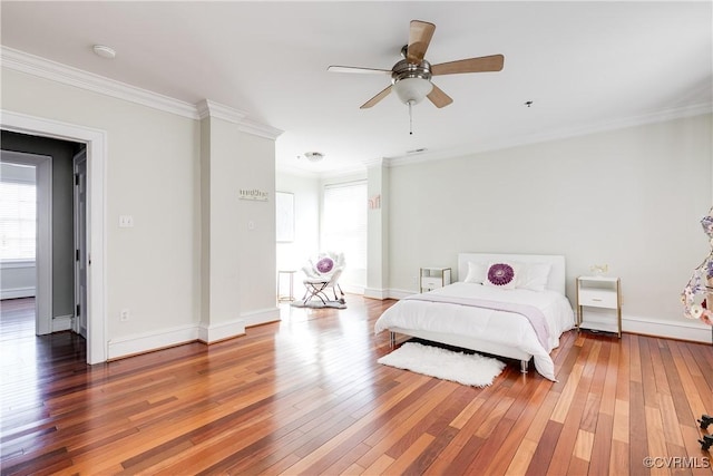 bedroom with multiple windows, ornamental molding, and wood finished floors