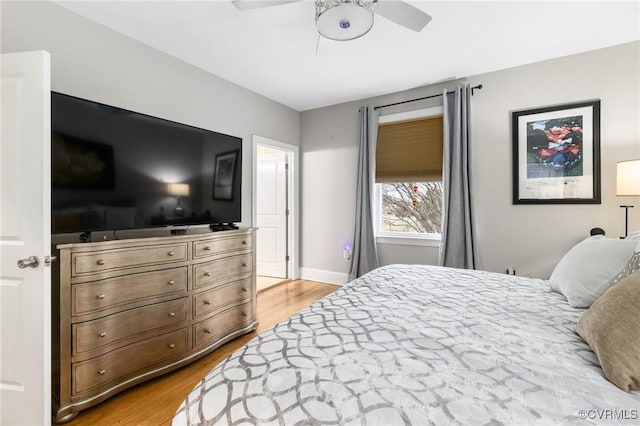 bedroom featuring baseboards, a ceiling fan, and light wood-style floors