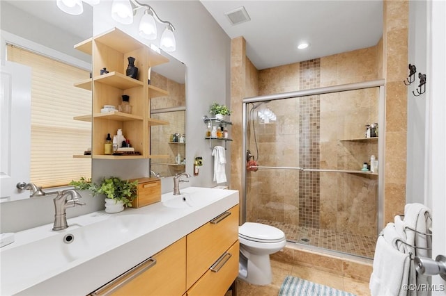 bathroom featuring visible vents, a sink, a shower stall, and toilet