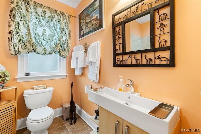 bathroom with toilet, baseboards, and tile patterned floors