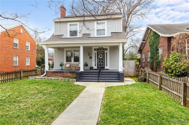 view of front of house with a fenced backyard, a chimney, a front lawn, and a porch