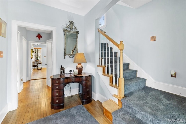 stairway featuring hardwood / wood-style flooring and baseboards