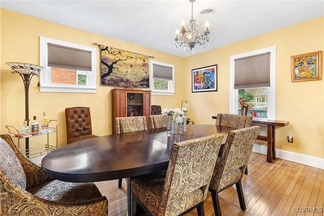 dining space featuring plenty of natural light, wood-type flooring, visible vents, and baseboards