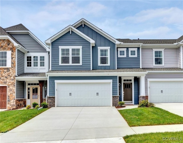 craftsman-style house with a garage, concrete driveway, board and batten siding, and stone siding