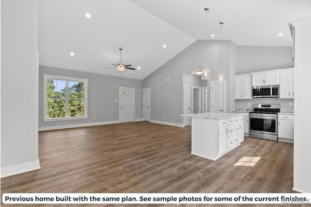 kitchen featuring a center island, light wood-type flooring, appliances with stainless steel finishes, white cabinets, and a ceiling fan