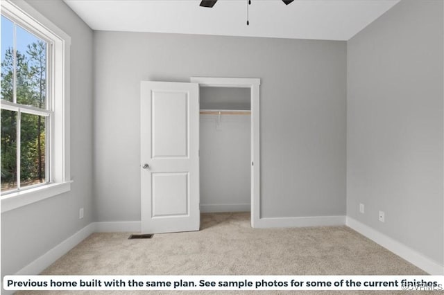 unfurnished bedroom featuring carpet flooring, visible vents, baseboards, and a closet