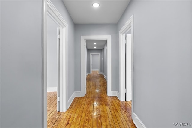 hall with light wood-type flooring and baseboards