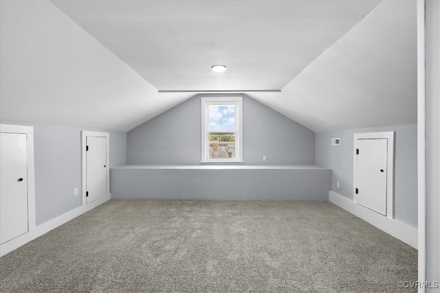 additional living space featuring lofted ceiling and carpet flooring