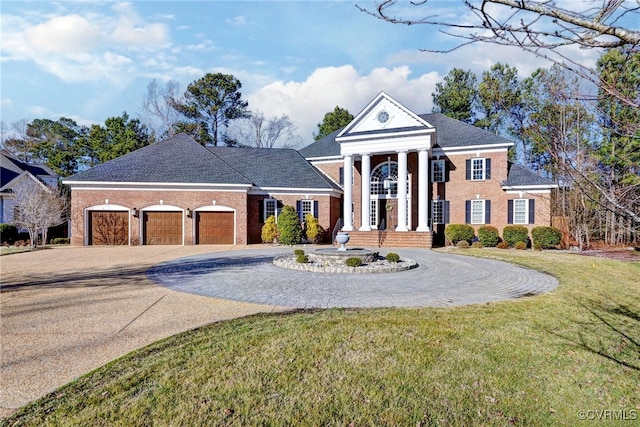 greek revival inspired property featuring a garage, a front yard, decorative driveway, and brick siding