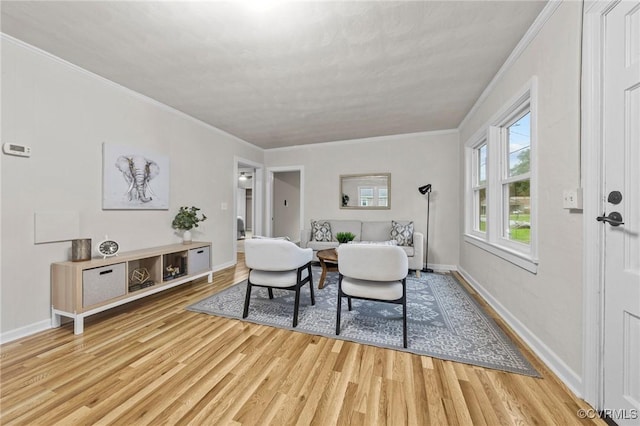 sitting room featuring light wood-style flooring, baseboards, and crown molding