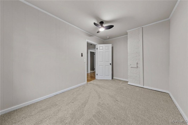 unfurnished bedroom featuring a ceiling fan, carpet, crown molding, and baseboards