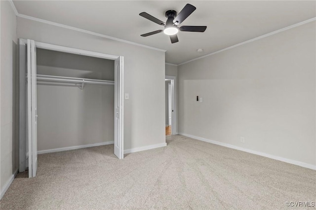 unfurnished bedroom featuring baseboards, light colored carpet, ceiling fan, ornamental molding, and a closet