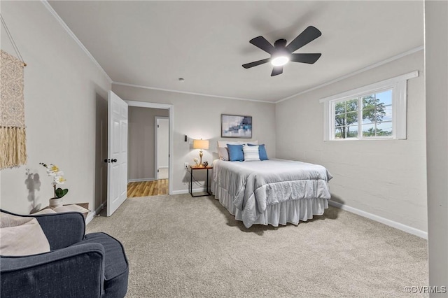 carpeted bedroom with a ceiling fan, crown molding, and baseboards